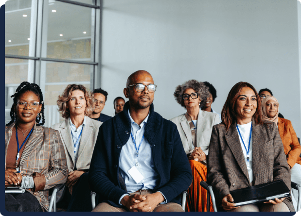 Diverse audience attentively listening at a conference.