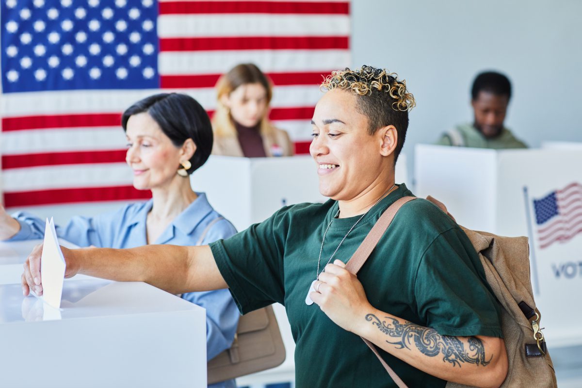 People voting at polling stations, American flag.