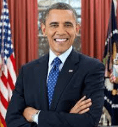 Smiling man in navy suit with American flags